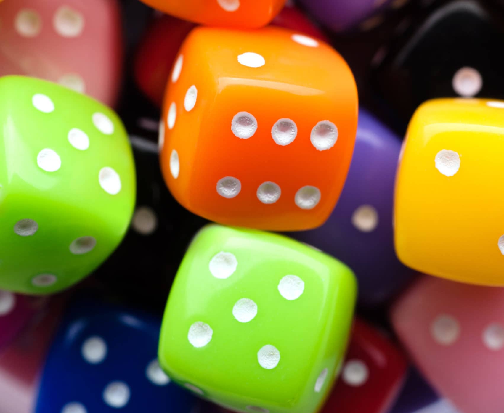 Assorted multicolor dices, close-up shot, abstract gambling background